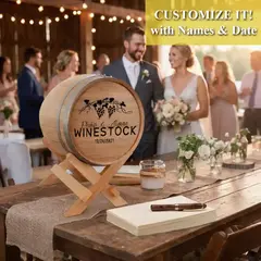 Custom engraved wedding barrel card collector centerpiece on rustic reception table with bride and groom in background