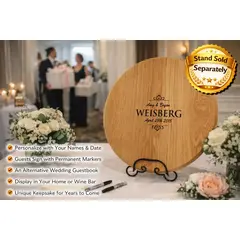 Custom engraved wooden wine barrel head wedding guestbook alternative displayed at reception table with floral decorations.