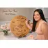 Wedding guest signing personalized wooden wine barrel head guestbook with well wishes for the bride and groom at a wedding reception.